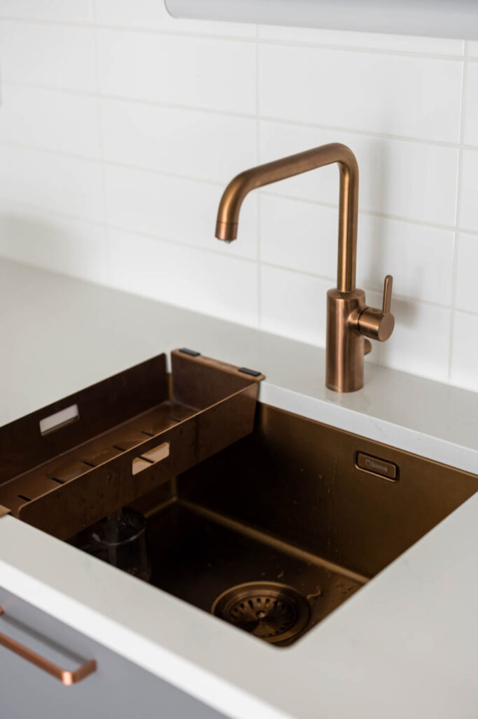 Sisustussuunnittelija Tampere Tilako Oy. Kerrostalotalokohteen remontti. Kuvassa keittiön kuparinen hana ja allas.